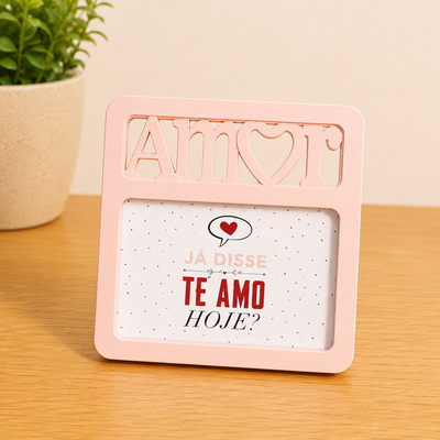 Porta retrato rosa claro com a palavra 'Amor' recortada, contendo uma mensagem em fundo branco com bolinhas.
