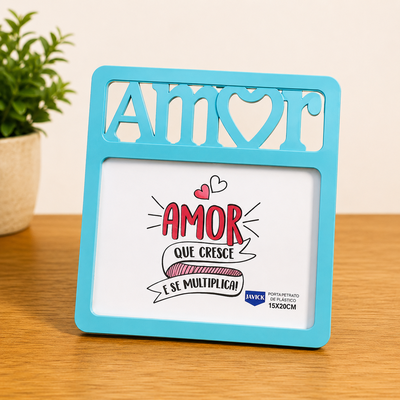 Porta retrato azul com a palavra 'AMOR' recortada, contendo uma ilustração com a frase 'AMOR QUE CRESCE E SE MULTIPLICA'.